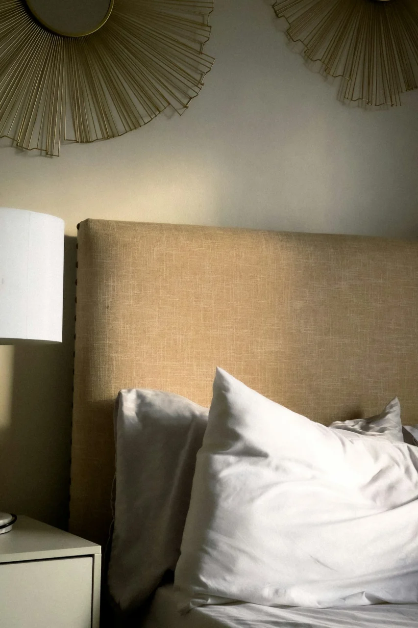a bed with a lamp and a pillow