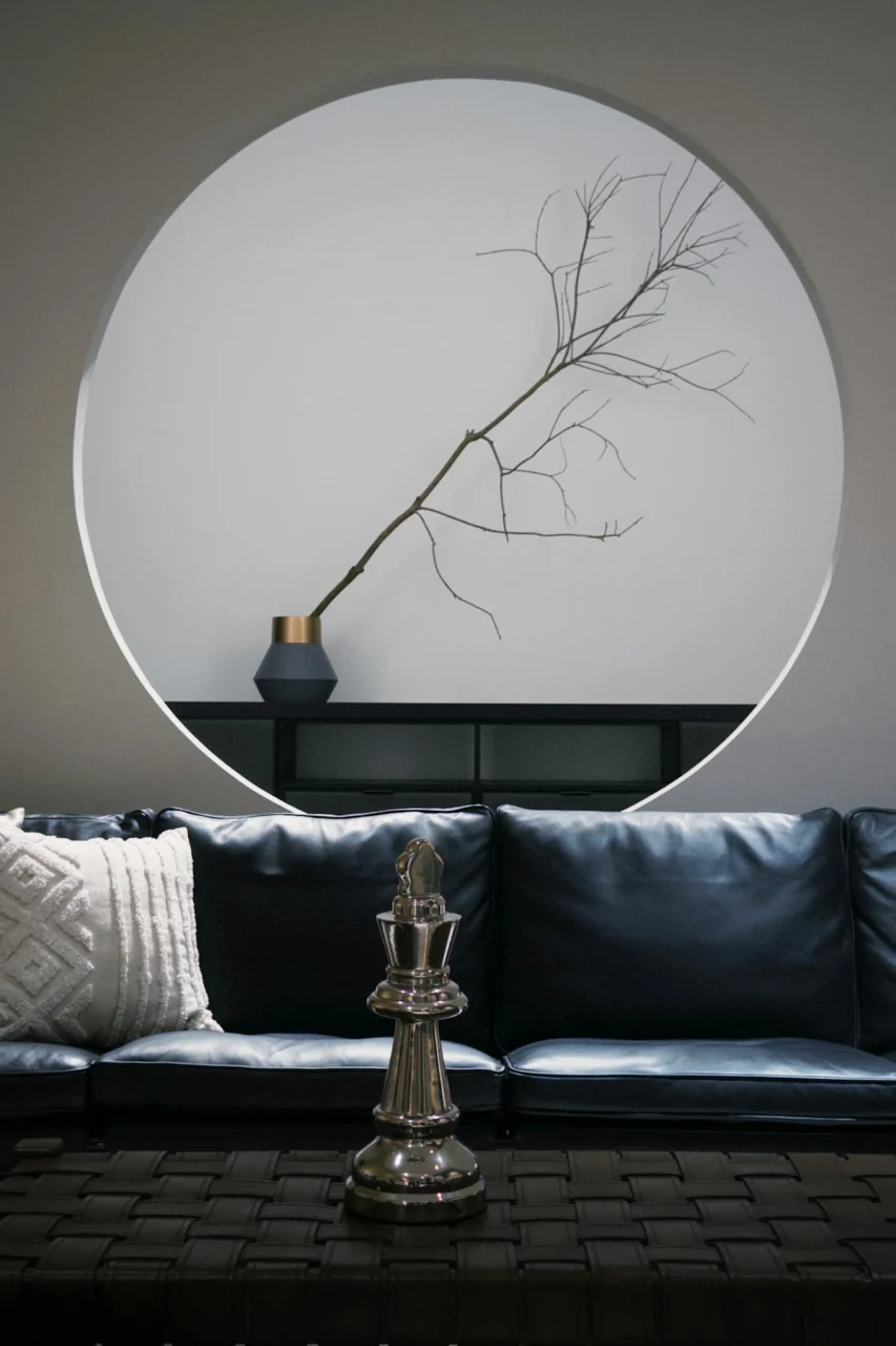 A black leather sofa with a chess piece and mirror