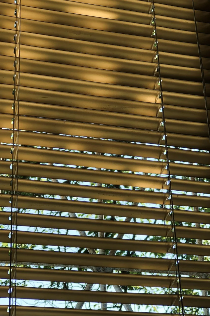 a close up of a window with a wooden blind
