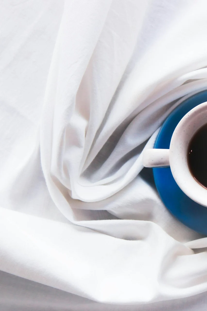 a cup of coffee sitting on top of a white cloth