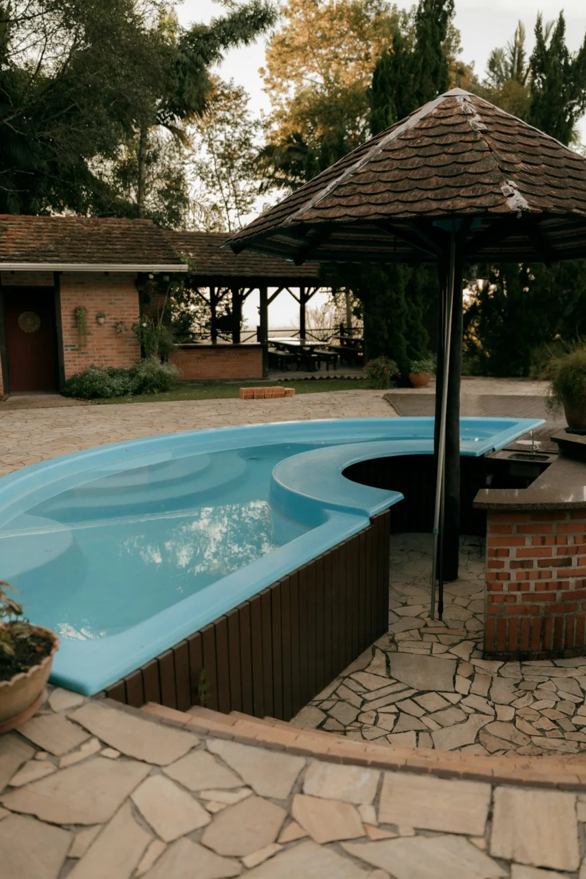 A curved blue swimming pool with an outdoor bar