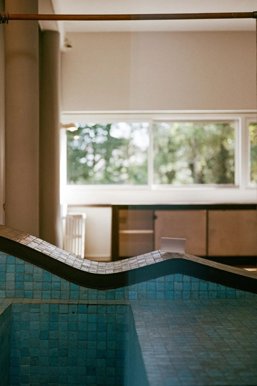 A curved tiled bench in a bright room with a large window