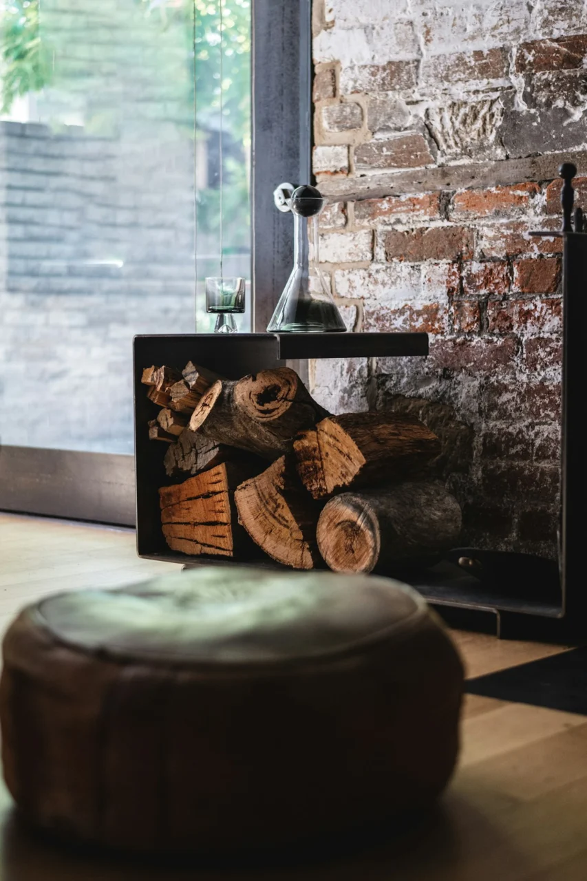 a fireplace with logs in front of a brick wall