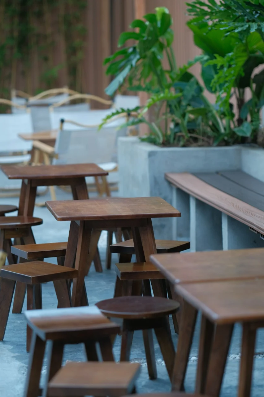 a group of wooden tables and chairs sitting next to each other