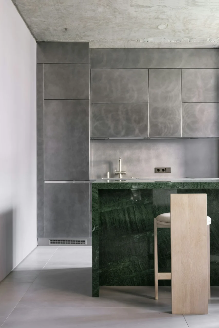 A kitchen with a marble counter top next to a bar