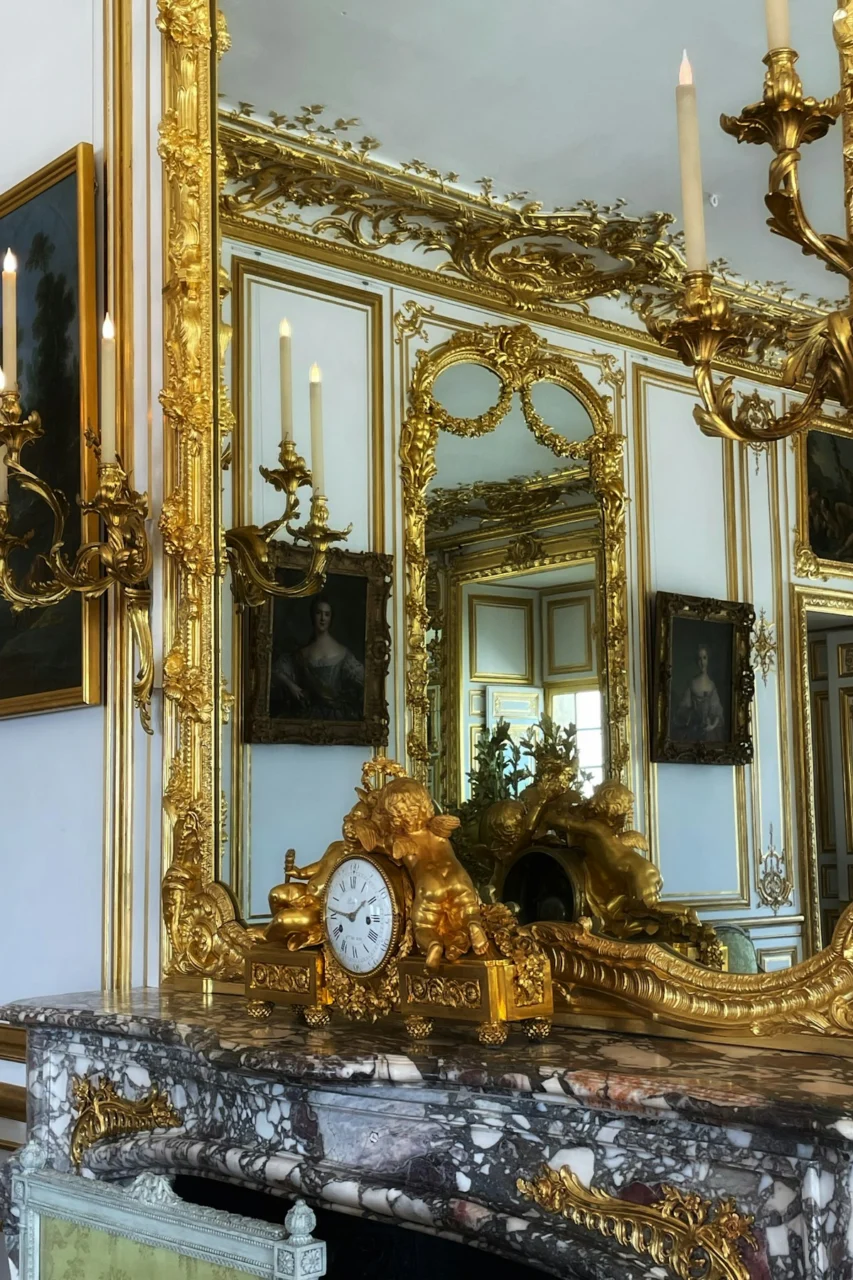 a large mirror with a clock on top of it