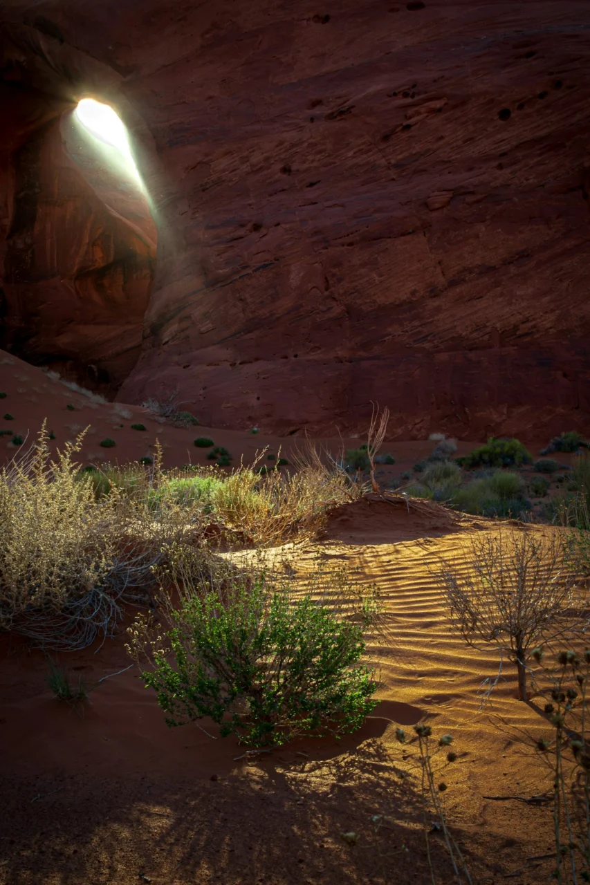 A light shines through a hole in the desert
