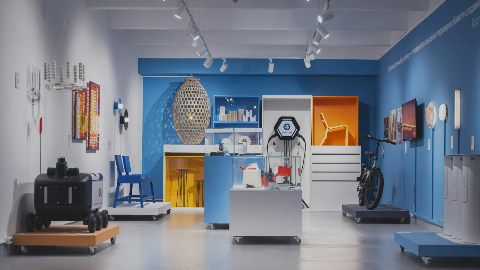 A modern industrial design exhibition with a robot, bicycle, and furniture on display