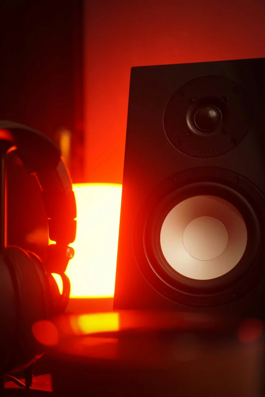A pair of headphones sitting next to a speaker