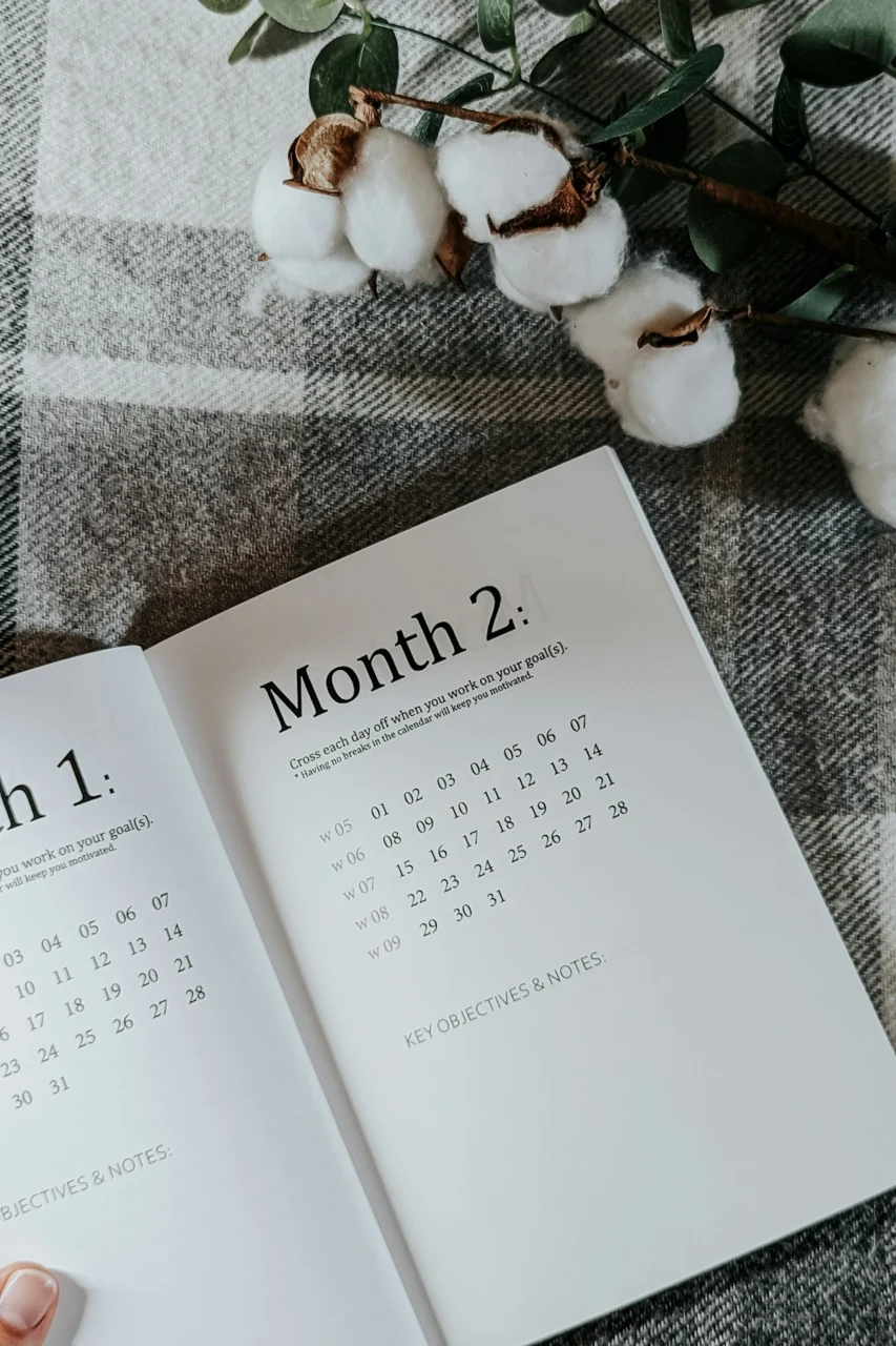 a person holding a book open to a calendar