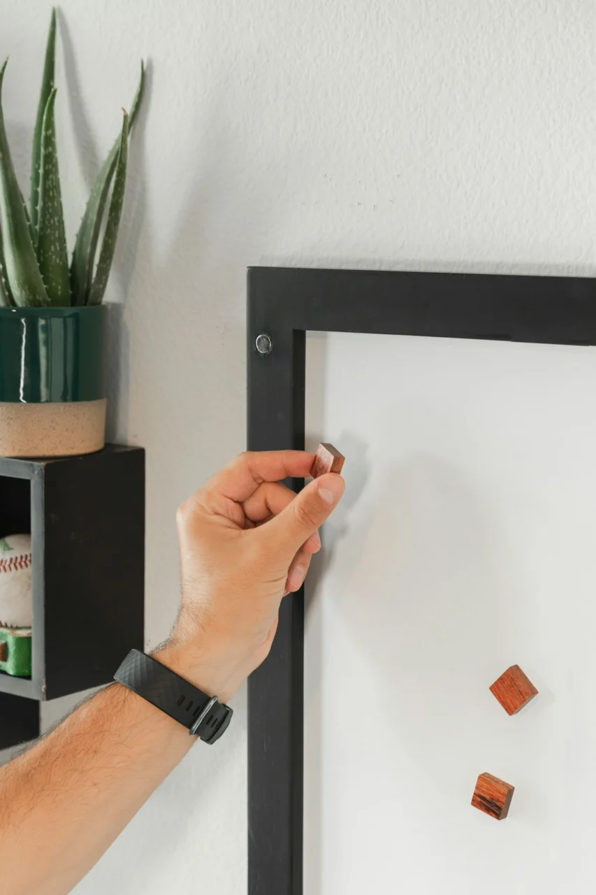 a person holding a pen and writing on a white board