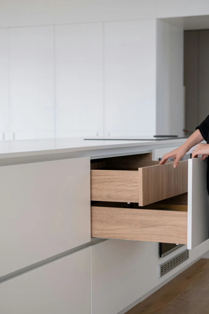 A person opens a modern kitchen drawer