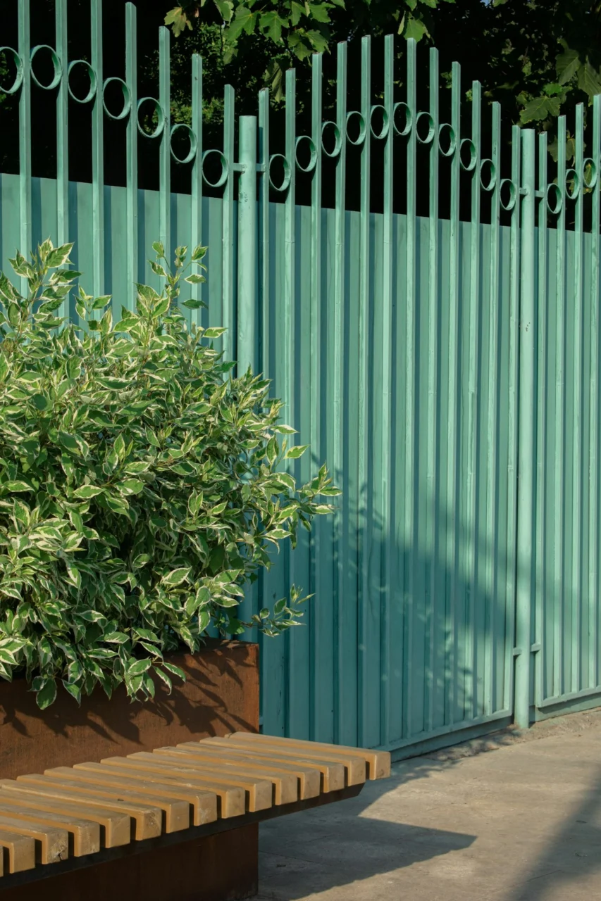 a plant in a planter next to a blue fence