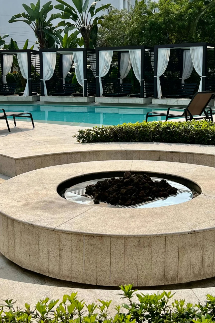 A pool with a fire pit in the middle of it
