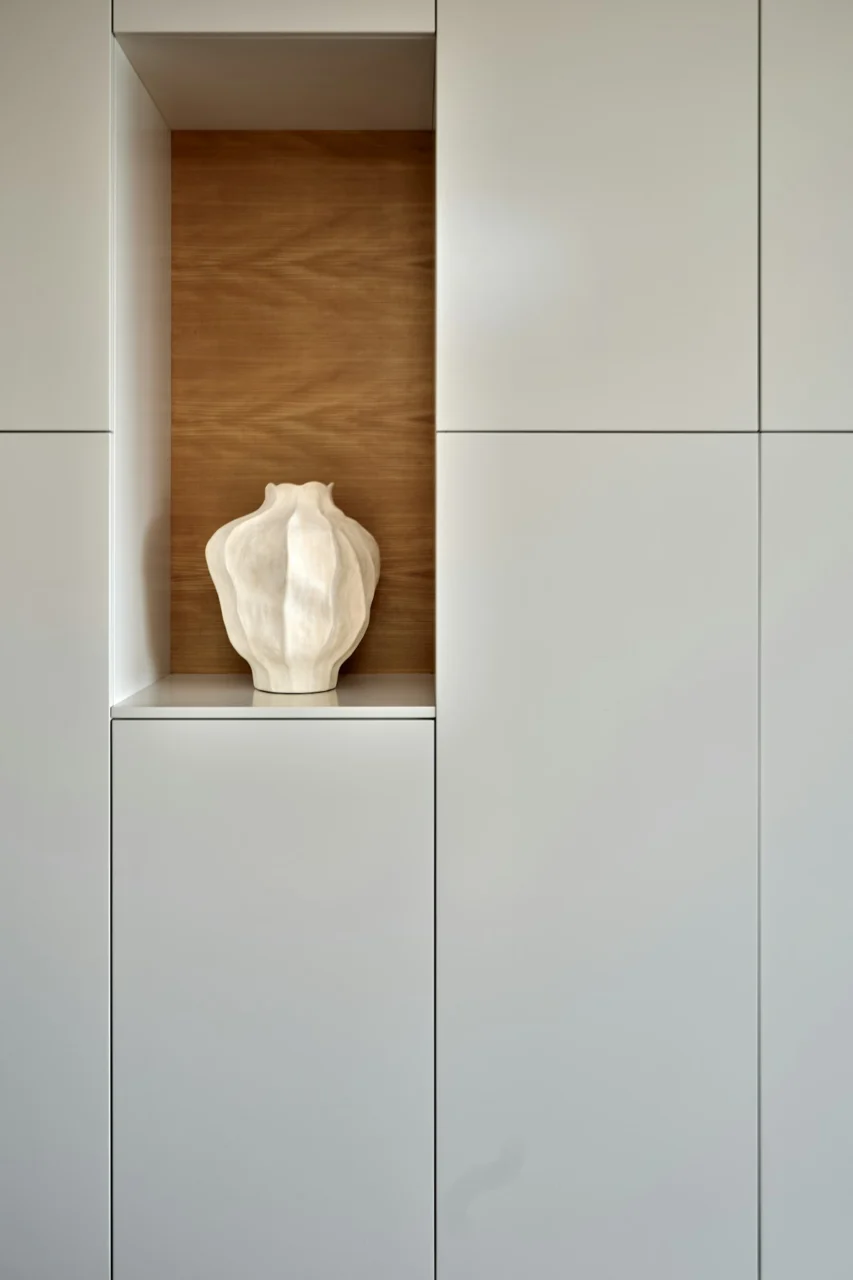 A sculptural vase sits in a built-in niche