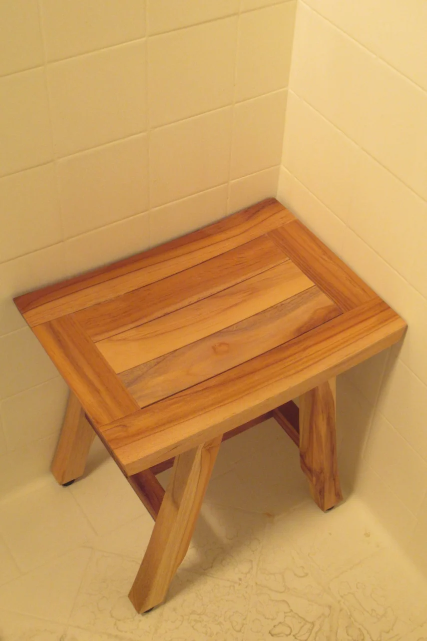 a small wooden table sitting in a bathroom