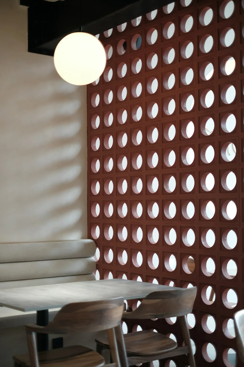 A table and chairs in front of a wall with circles on it
