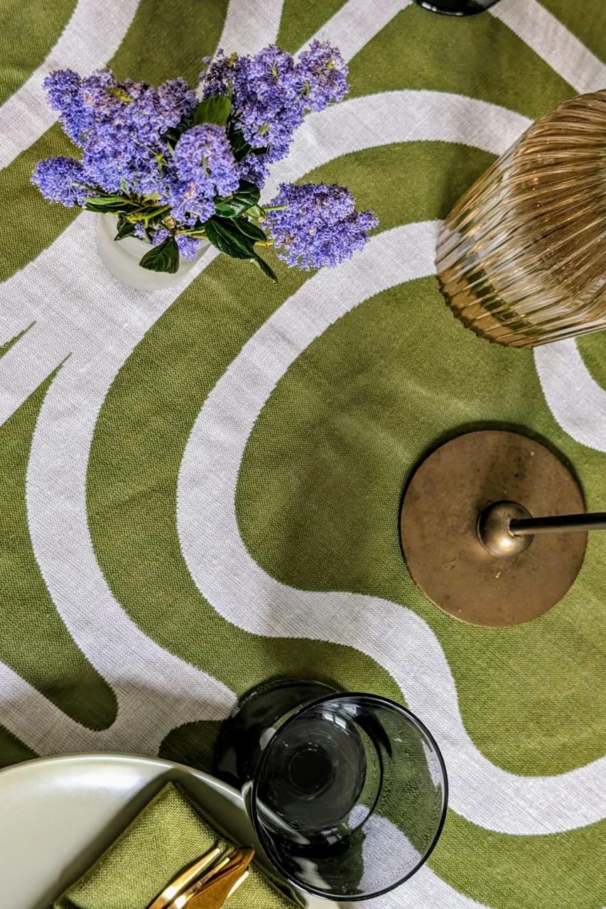a table topped with a vase of purple flowers