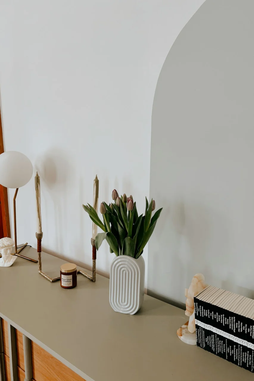 a table with a vase of flowers and a book on it