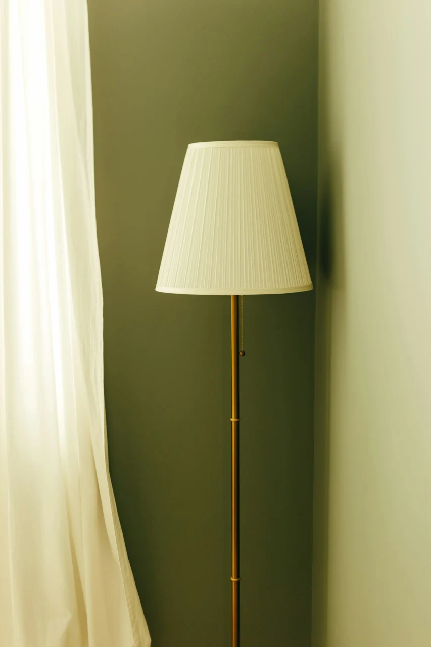 A tall floor lamp with a white shade