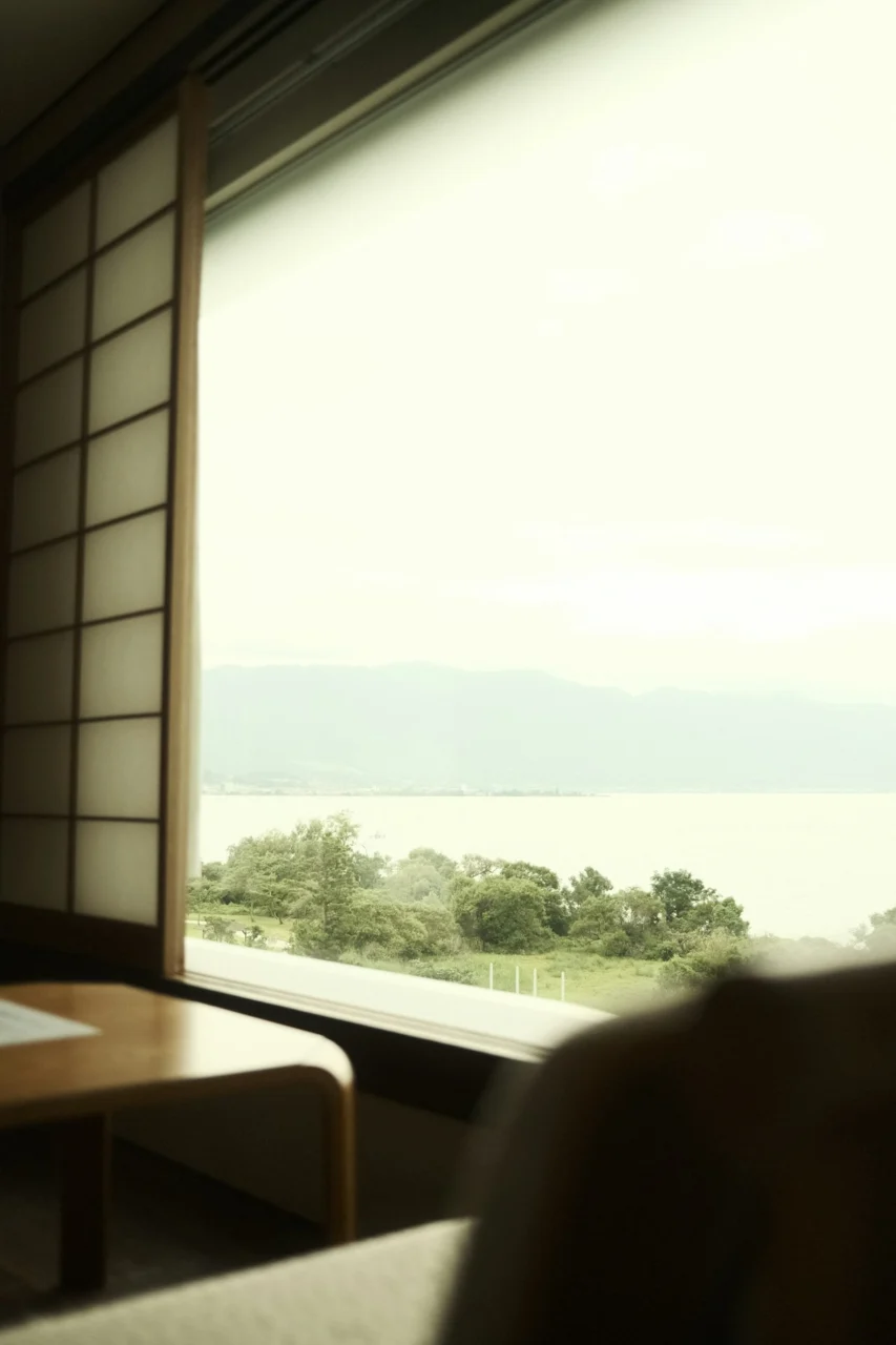 A view of a lake and distant mountains through a shoji screen window