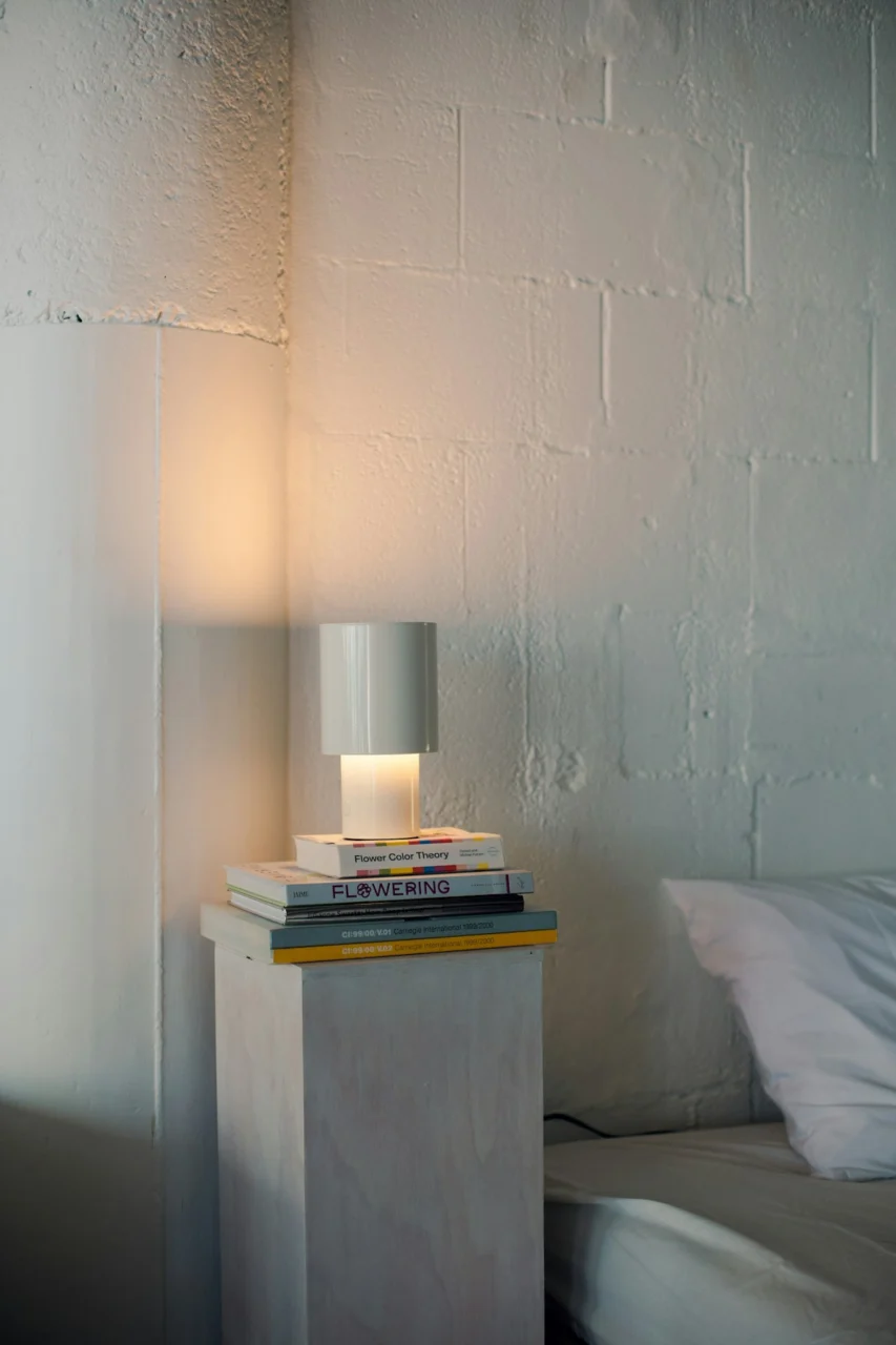 A white lamp sits on a stack of books