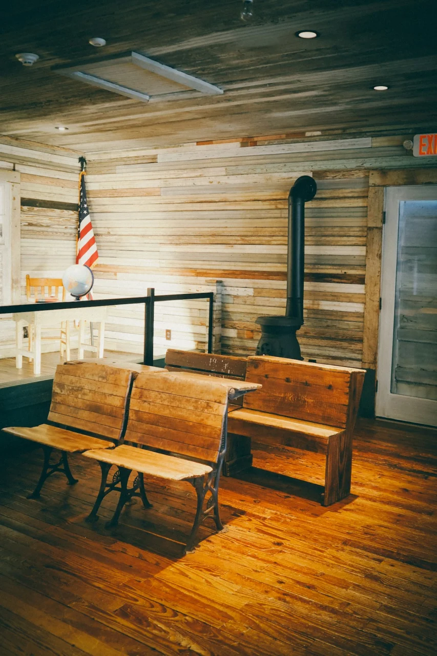 A wooden bench sitting on top of a hard wood floor