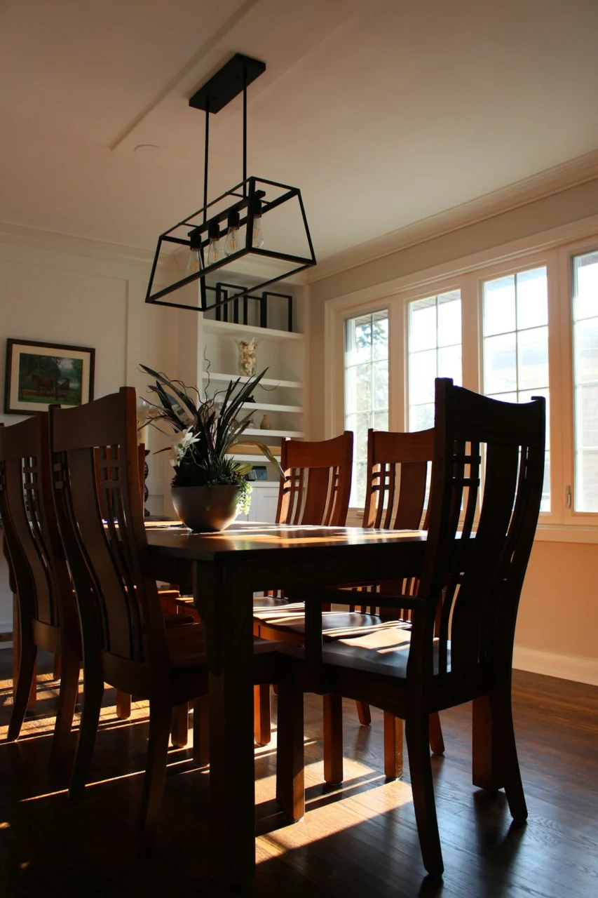 A wooden dining table with chairs and a chandelier