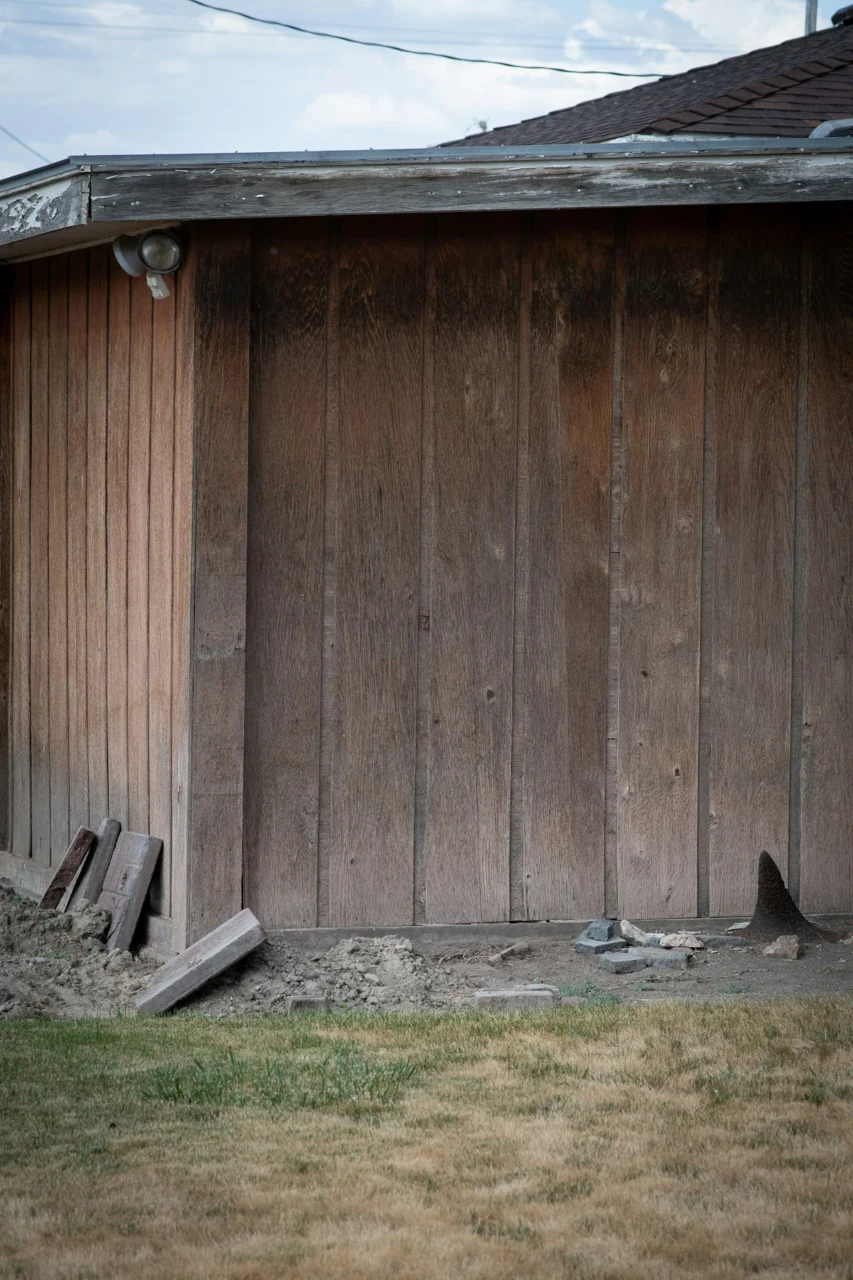 a wooden fence with a bird in front of it