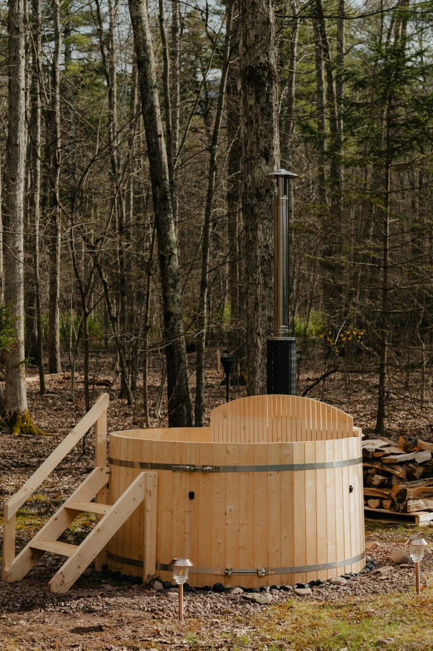 a wooden hot tub in the middle of a forest