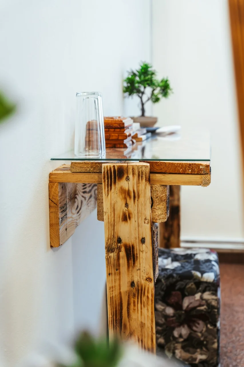 a wooden table with a glass vase on top of it