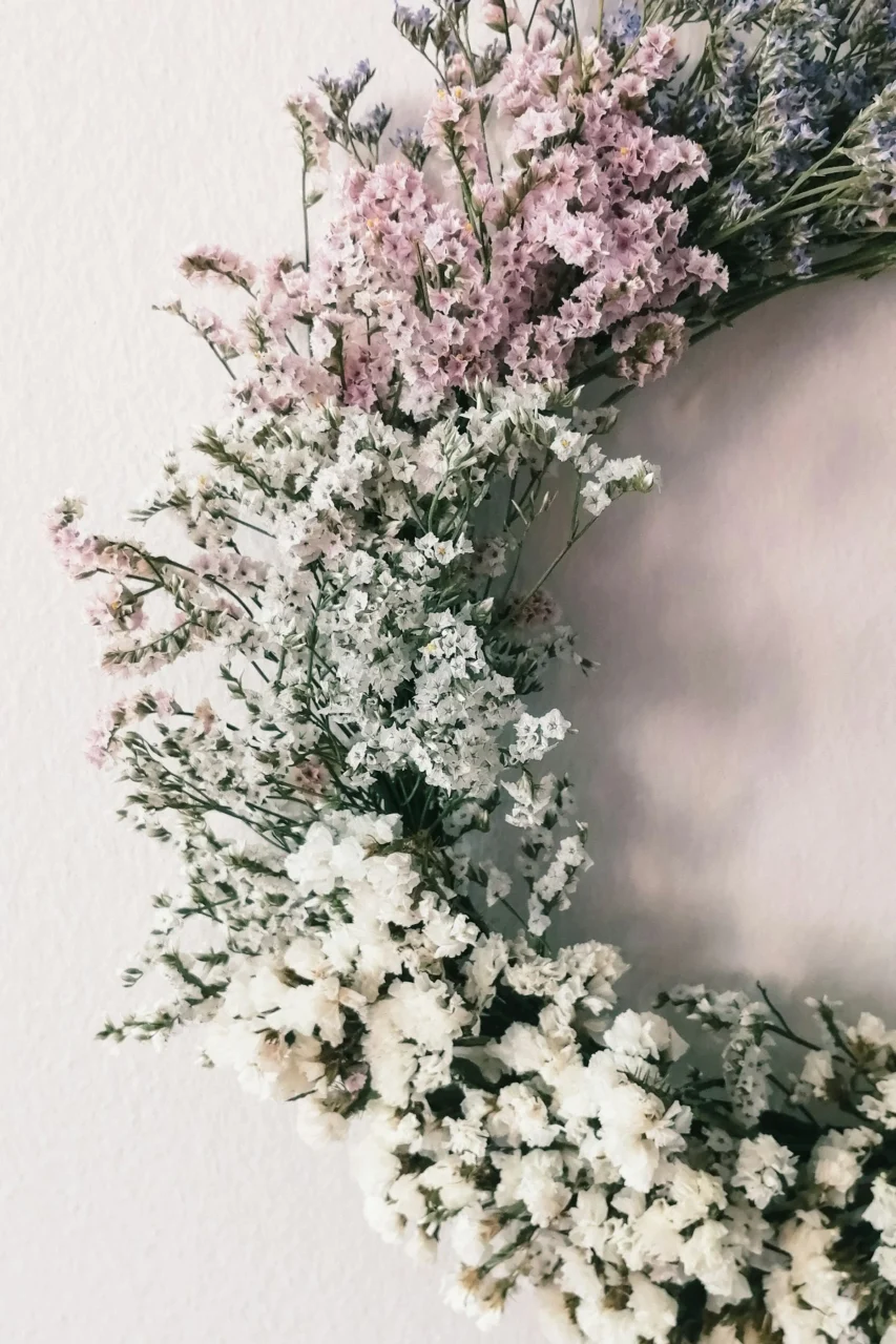 a wreath of dried flowers hanging on a wall