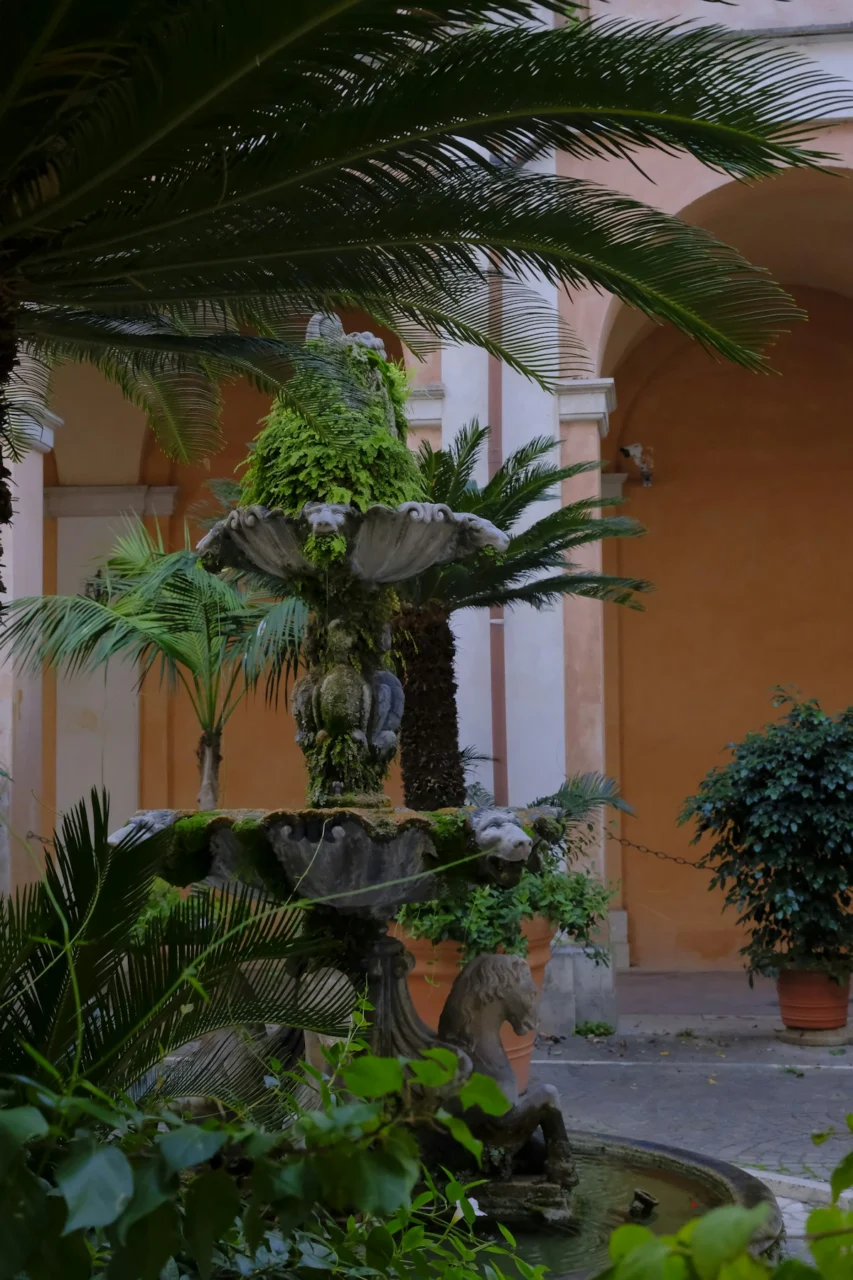 An old fountain covered in green plants and vines