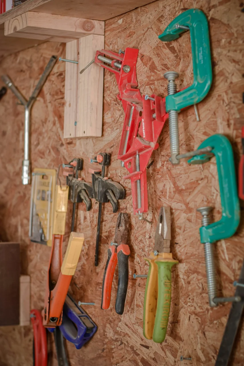 assorted hand tools on brown wooden wall
