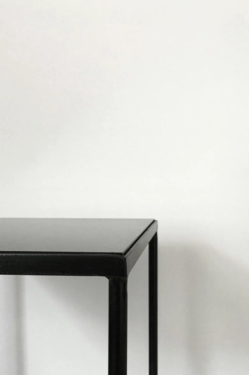 black metal table near white panted wall