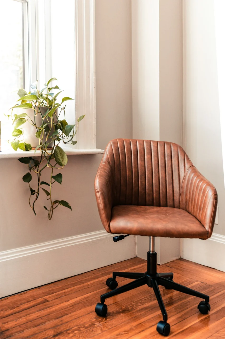 brown and black rolling chair beside green plant