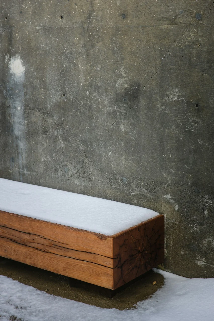 brown wooden table beside gray concrete wall