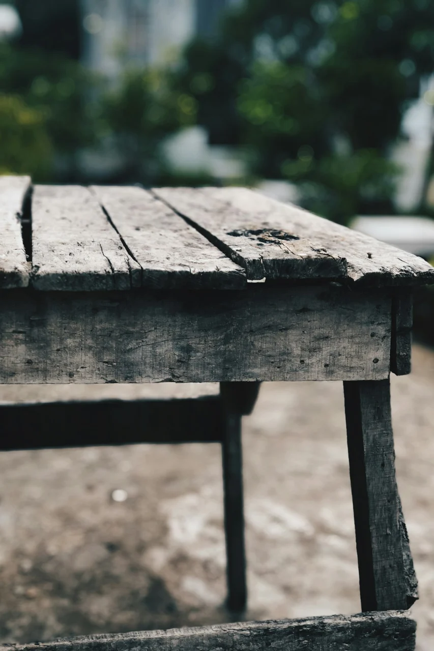 brown wooden table near green grass during daytime