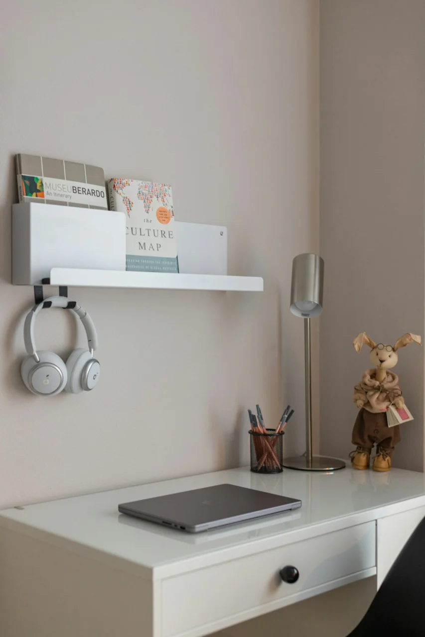 Desk with laptop, headphones, lamp, and stuffed bunny