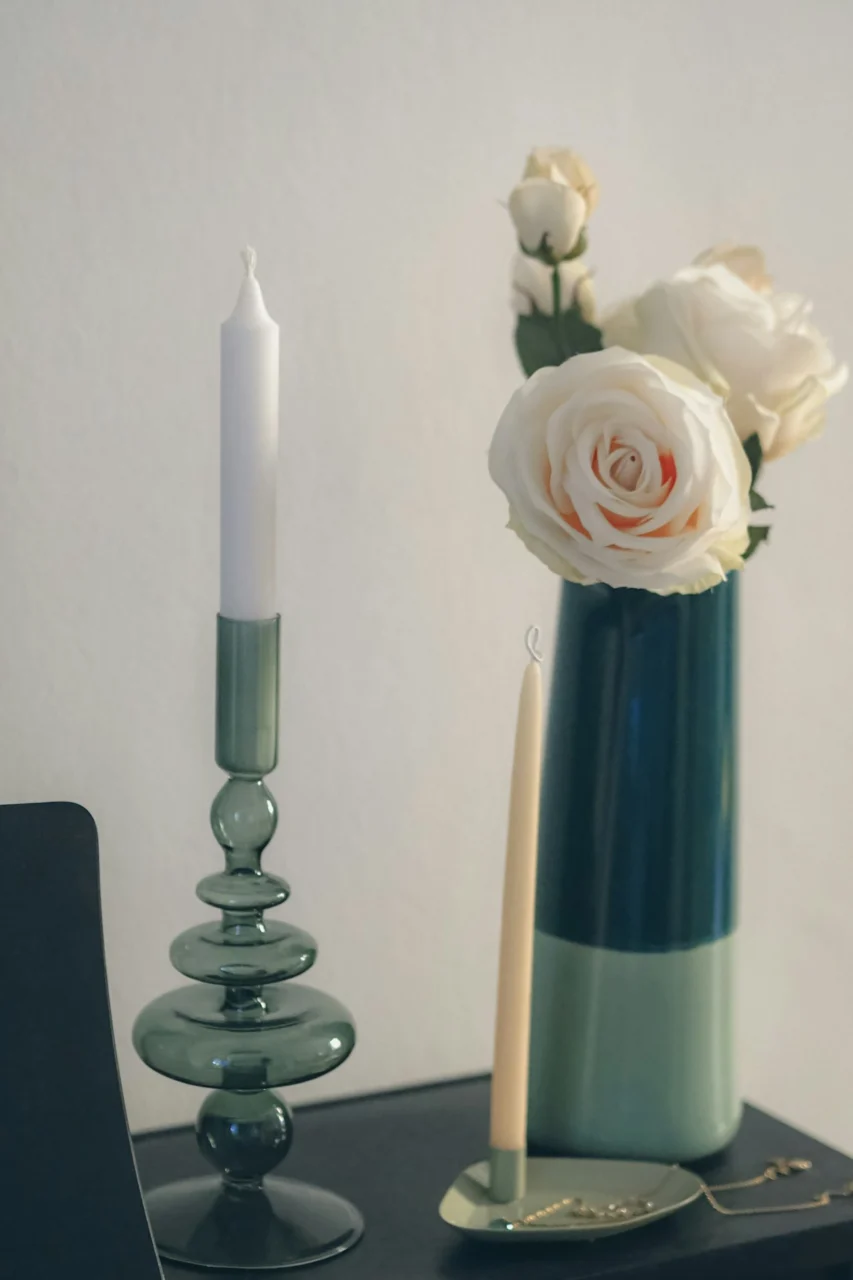 Elegant green candlestick and white roses in a two-tone vase