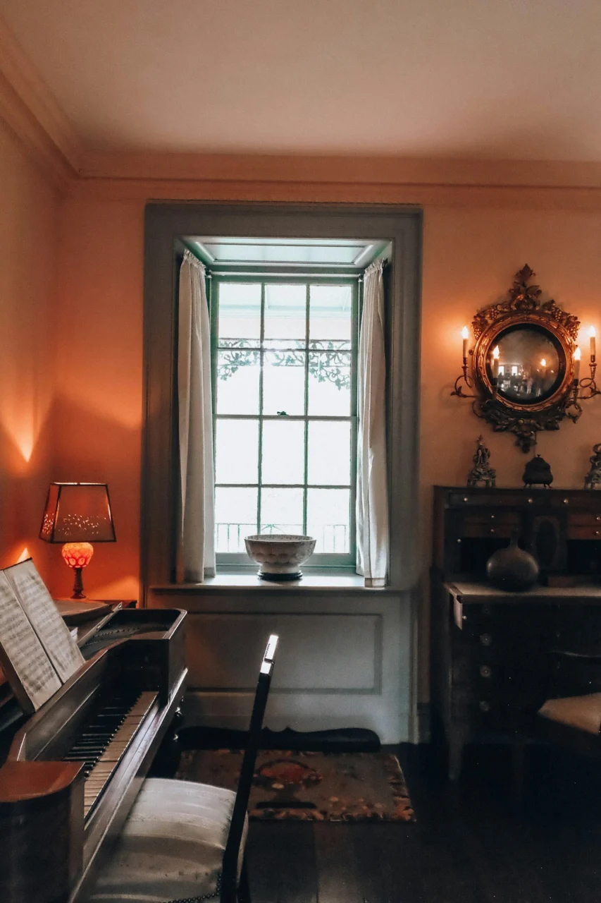 Elegant room with a piano, window, and antique furniture