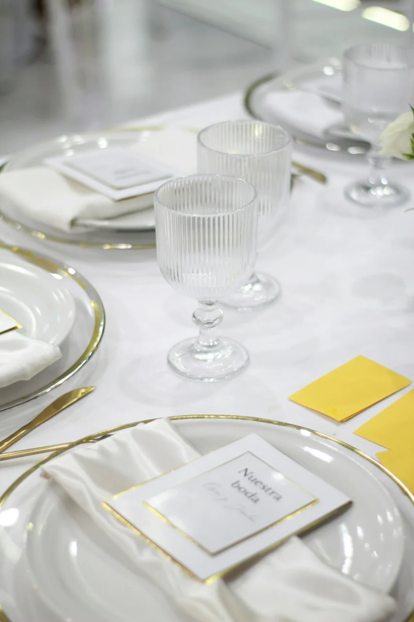 Elegant table setting with wedding invitations and glassware