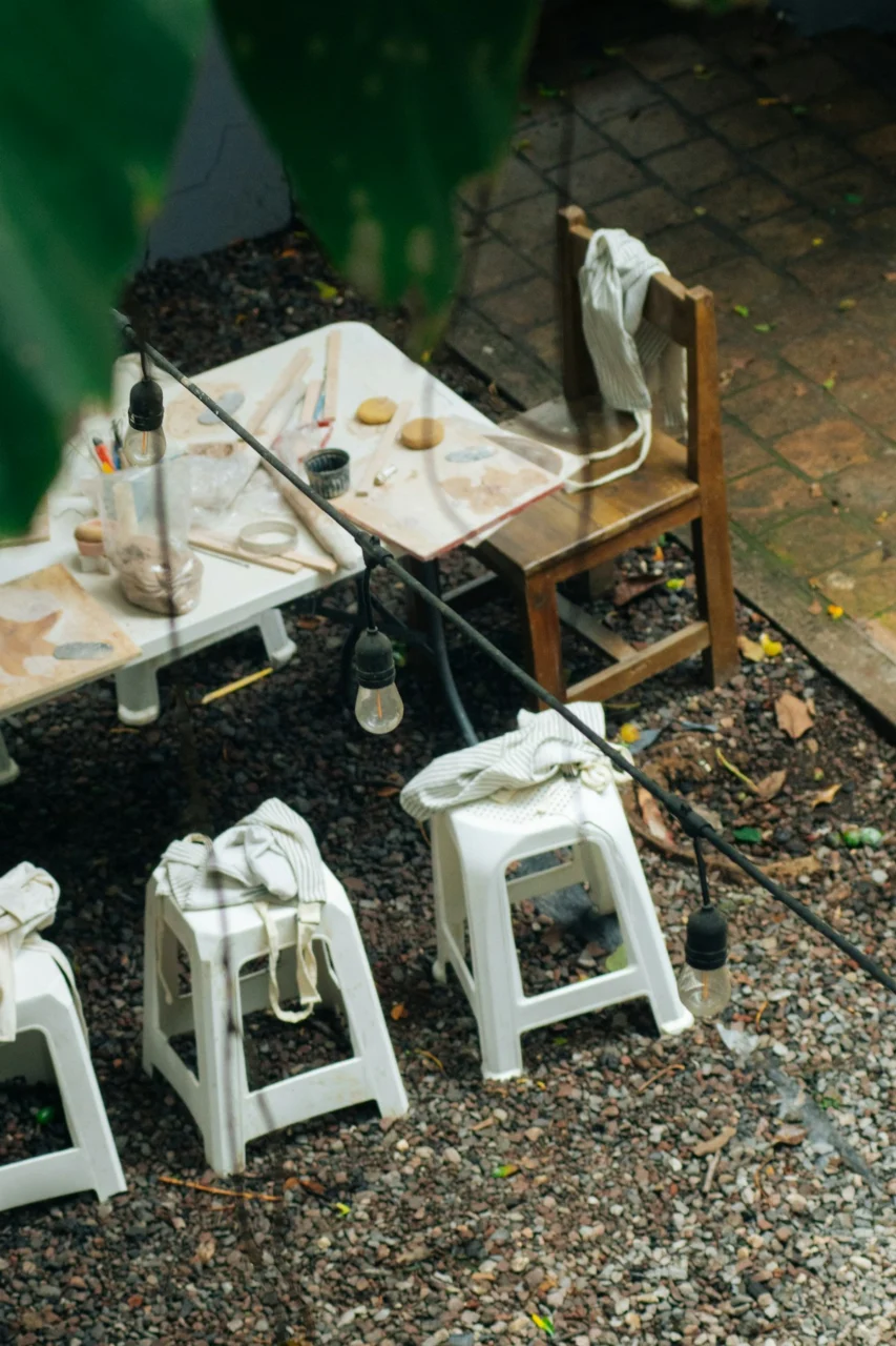 Gravel patio with white table, wooden chair, and string lights