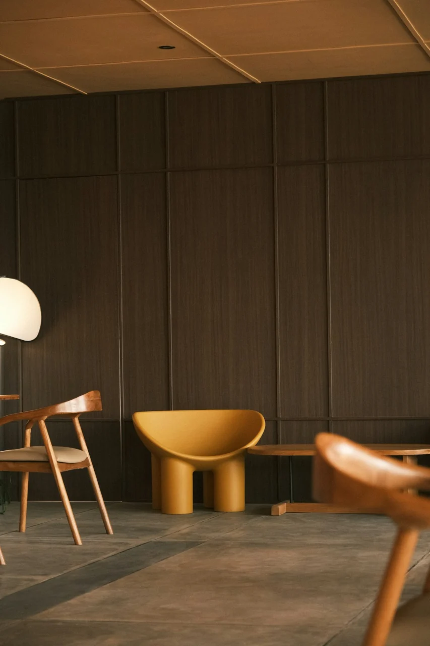 Modern chairs and yellow stool in a room