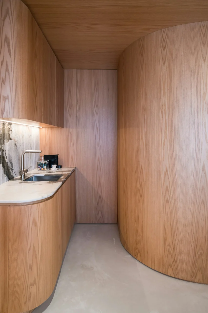 Modern curved wooden kitchen with marble accents