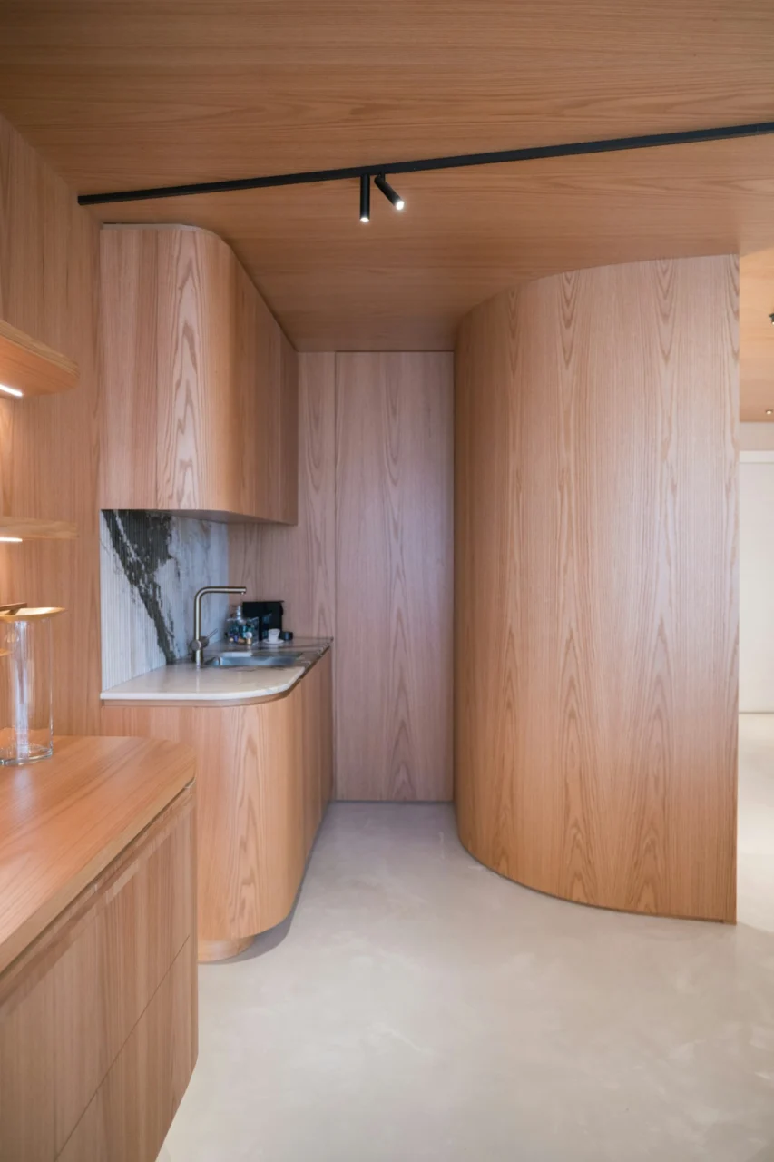 Modern kitchen with curved wooden cabinets and marble backsplash