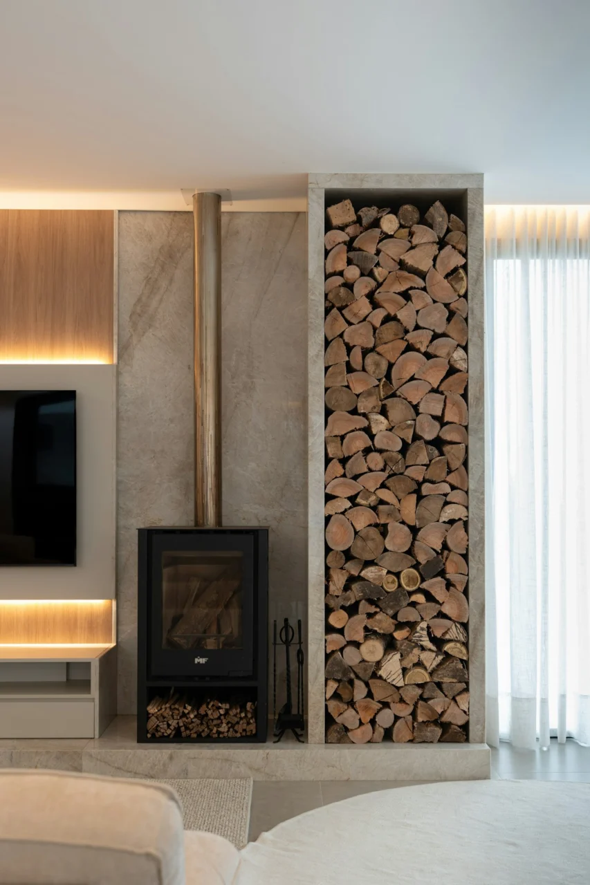 Modern living room with wood-burning stove and stacked firewood