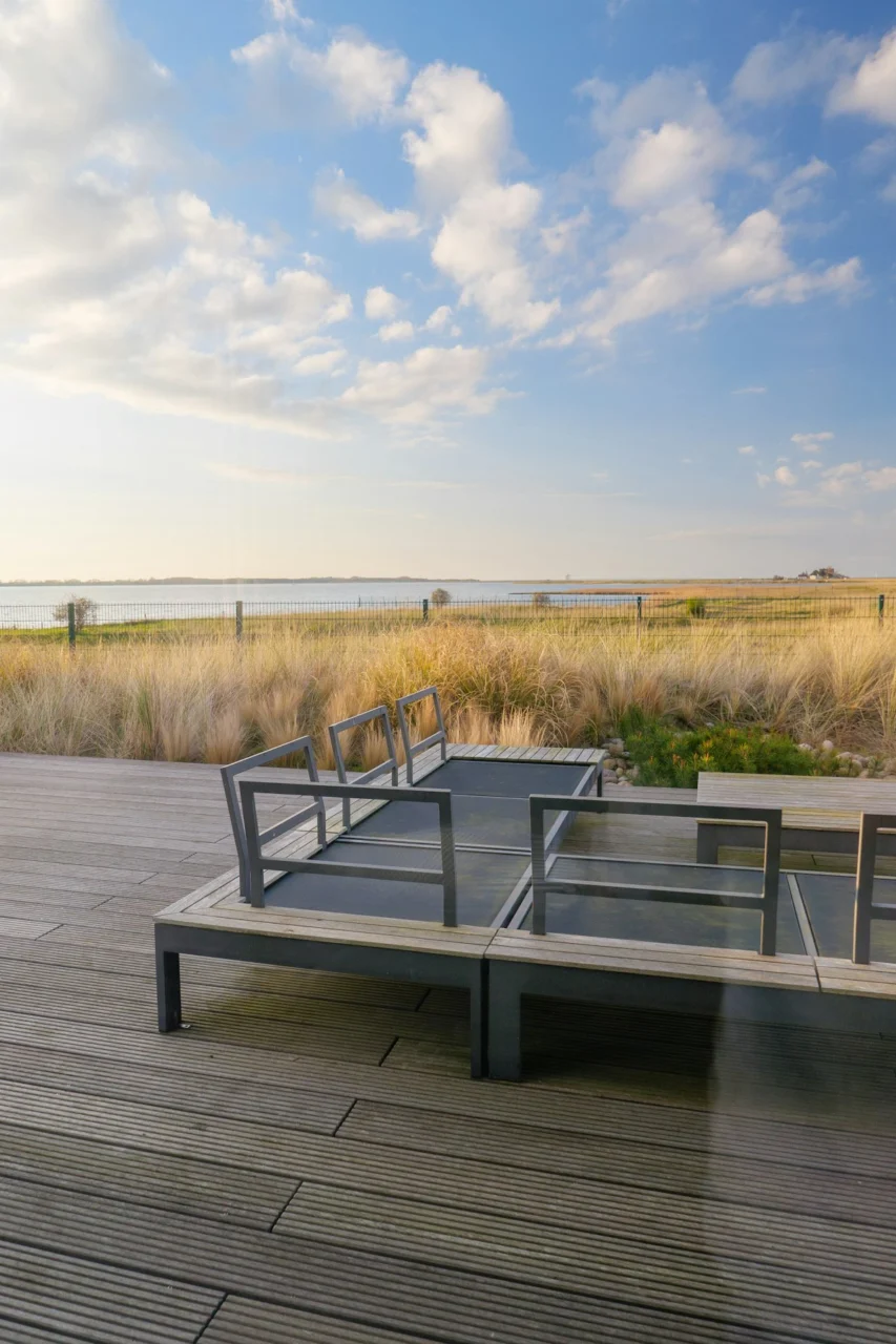 Modern outdoor seating area overlooking a tranquil bay