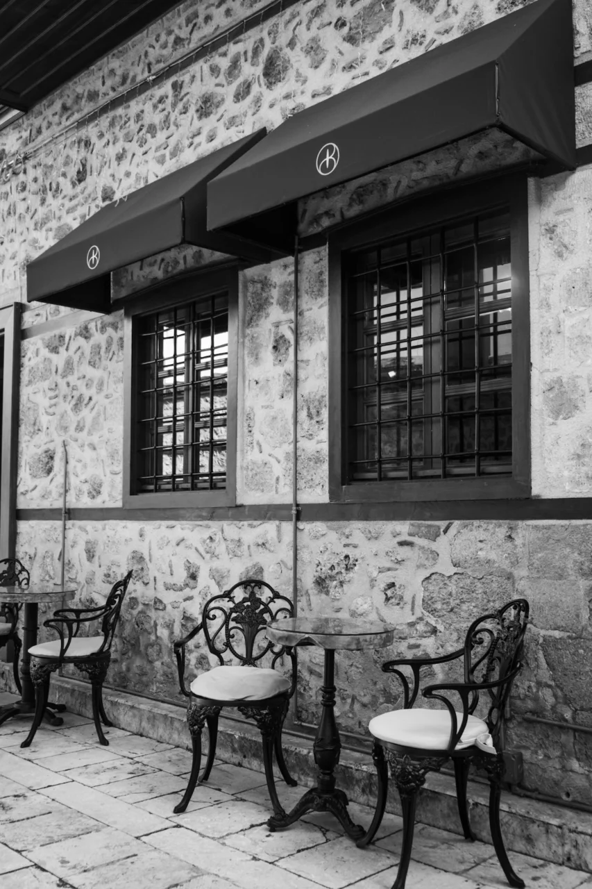 Ornate chairs and tables outside a stone building
