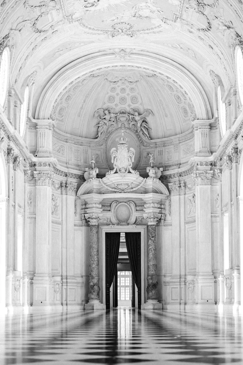 Ornate white hall with checkered floor and arched ceiling